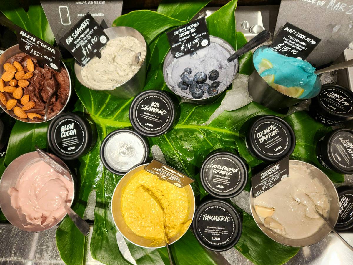 A close-up image of fine green seaweed powder in a bowl next to fresh seaweed strands.