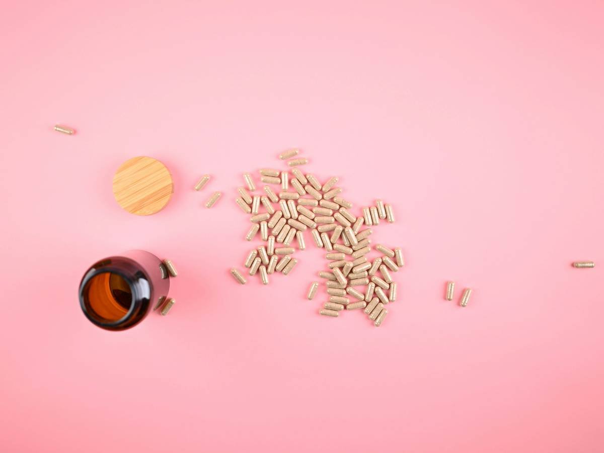 amber glass pill bottle with filled capsules poured on table - Photo courtesy of https://blated.com - credit appreciated