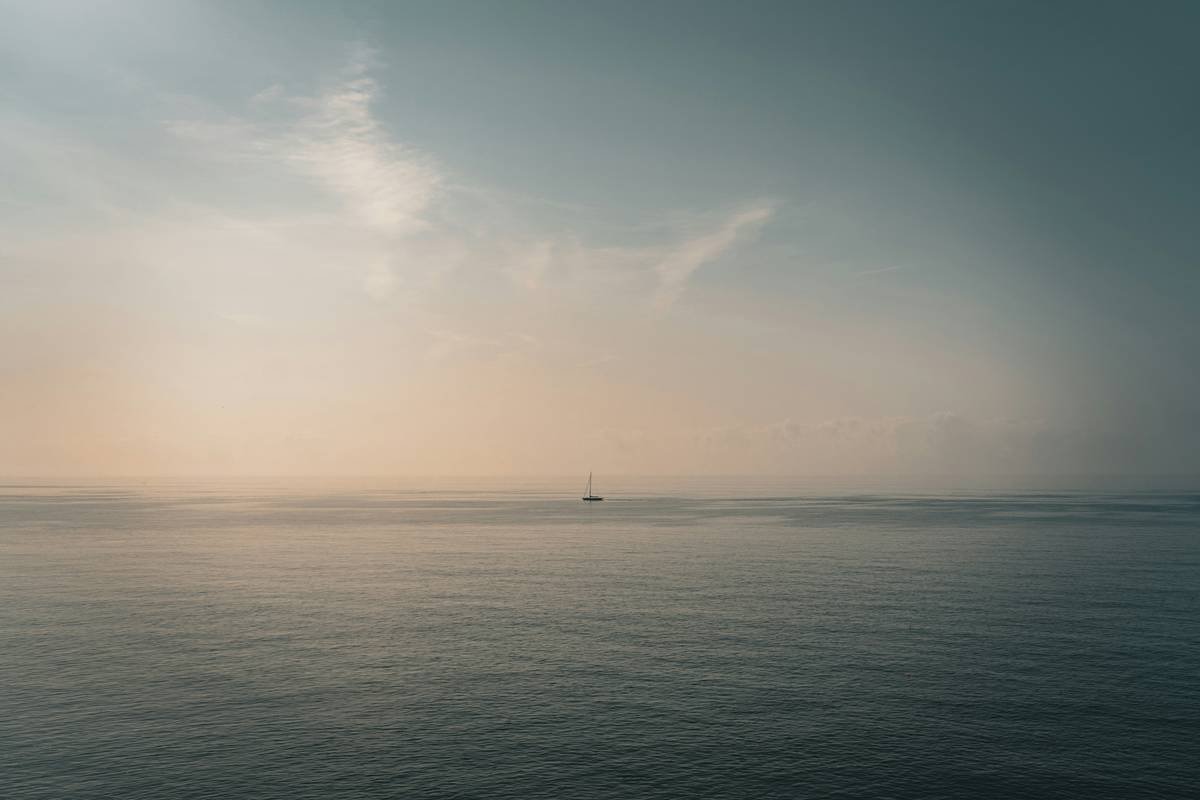 A boat in the morning haze, a mystical scene.