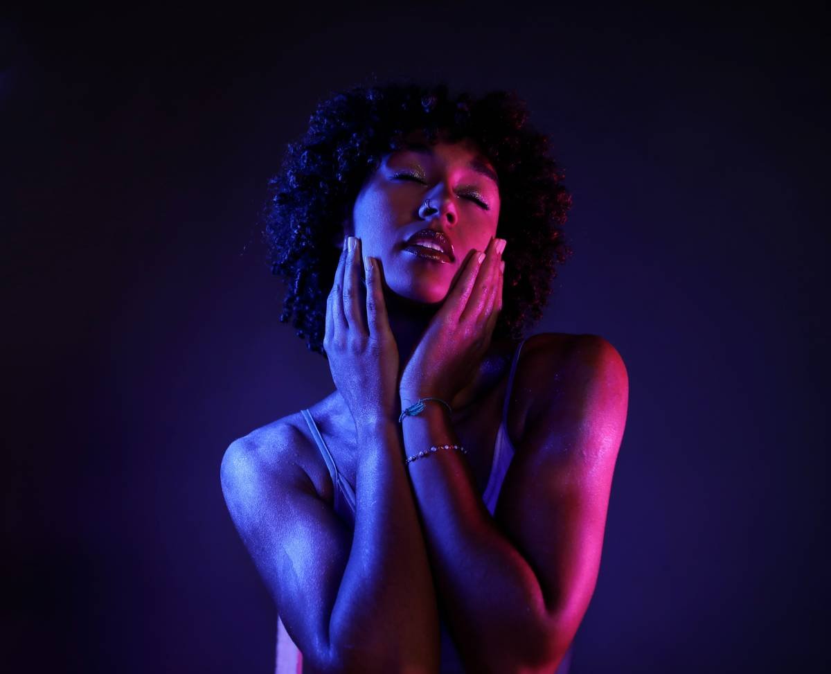 A naked woman with her hands on her face