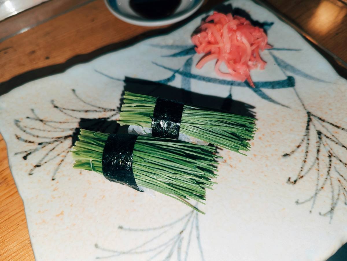 chara supplement capsules next to fresh organic seaweed on a marble surface